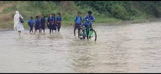 जान जोखिम में डाल बहती नदी को रोजाना पार करते हैं स्कूली बच्चे