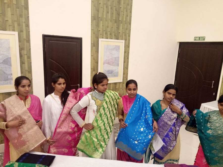 खुद द्वारा तैयार बनारसी साड़ियों का प्रदर्शन करती बुनकर बेटियां
