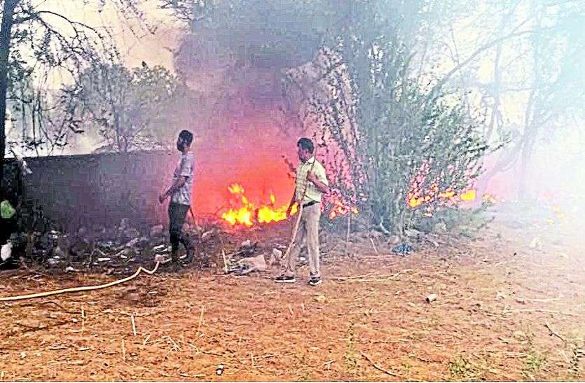 खेत में आग को बुझाते लोग। कचरा डिपो में जला रहे थे कचरा, पेड़ों मेें लगी आग कचरे की आग खेत में फैली, पेड़ जले