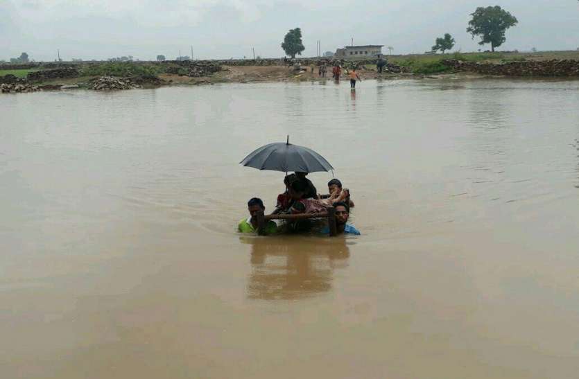 250 family, bridge, river, problem, sheopur news in hindi, mp news बीमार को खाट पर लिटाकर गले तक पानी में तैरते हुए ले जाते हैं अस्पताल