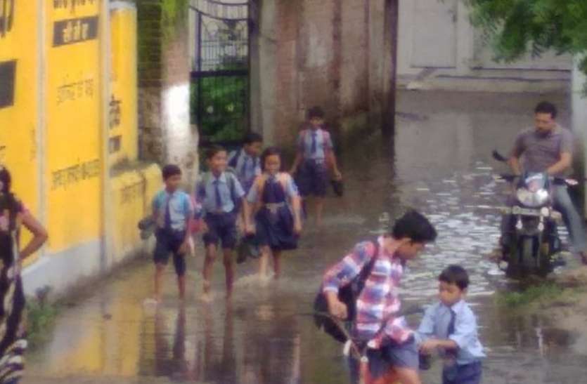 Children crossing water in colony school कॉलोनी में पानी को पार कर बच्चे जाते हैं स्कूल
