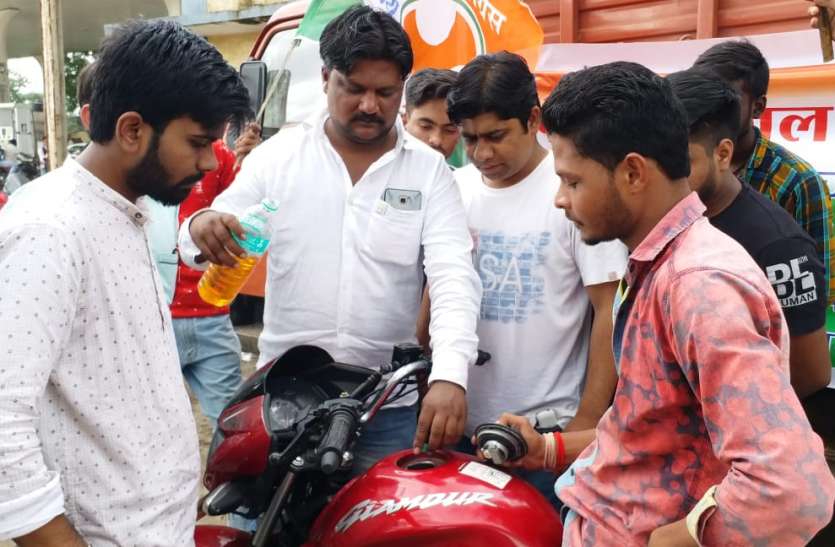 Protest चम्मच से गाड़ी में पेट्रोल डालकर जता रहे महंगाई का विरोध
