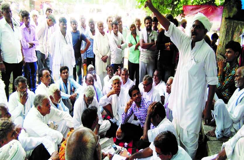धरने पर बैठे किसान। कार्रवाई की मांग को लेकर धरने पर बैठे किसान