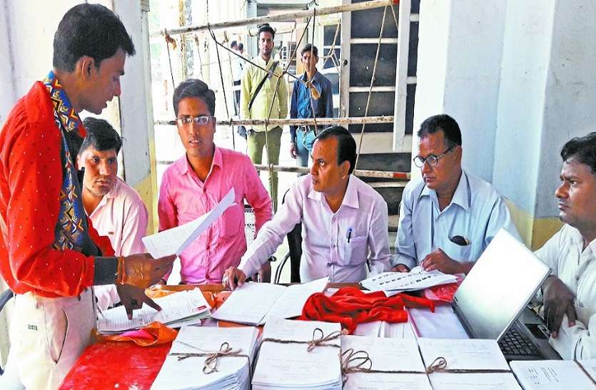 फॉर्म के बारे में जानकारी लेते लोग। प्रत्याशी नामांकन का खुला खाता