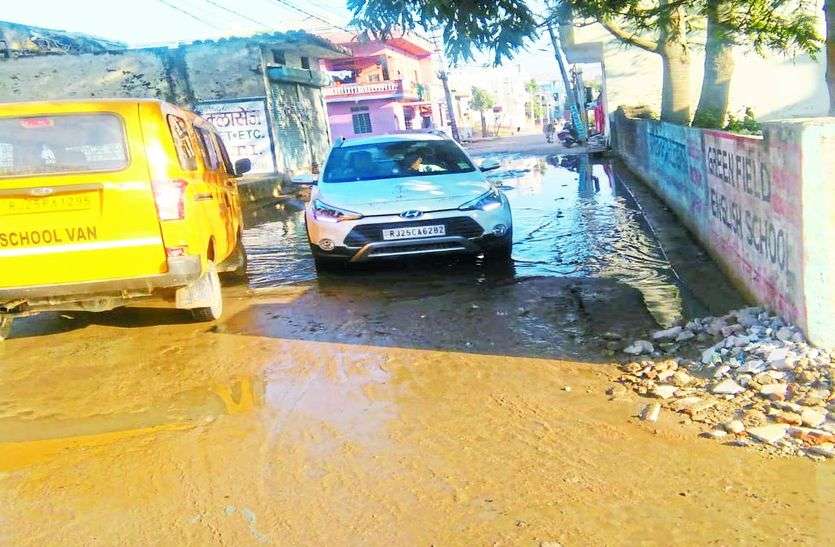 कीचड़ भरे रास्ते से निकलते वाहन। कीचड़ भरे रास्ते से गुजरने को मजबूर लोग