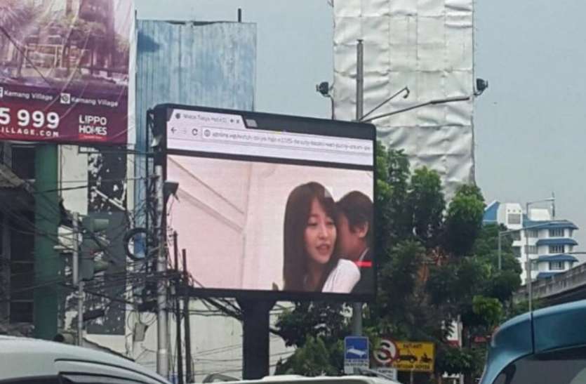 hoarding in china accidentally played porn clip onlookers shocked सड़क किनारे लगे होर्डिंग पर अचानक चलने लगी अश्लील फिल्म, 90 मिनट तक लोग खींचते रहे तस्वीरें, बनाई वीडियो