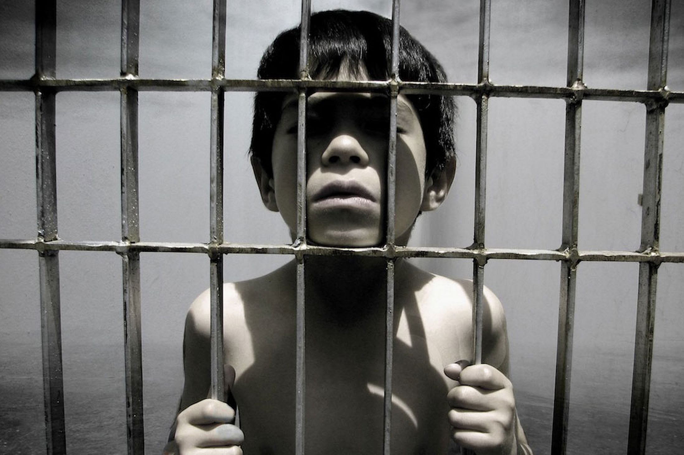 Дети в клетках 3. Ребенок за решеткой. Мальчик за решеткой. Тюрьма для детей. Тюрьма для несовершеннолетних.