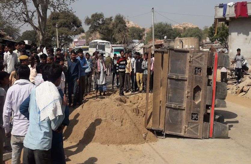 रास्ते से ट्रैक्टर ट्रॉली हटाते हुए। बजरी से भरी ट्रैक्टर-ट्रॉली पलटी