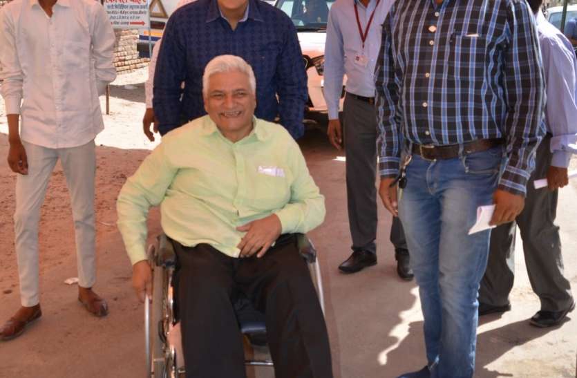 When the District Electoral Officer drove the voter's wheel chair hims जब जिला निर्वाचन अधिकारी ने मतदाता की व्हील चेयर खुद चलाई