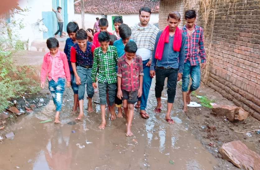 Children go to school from roadside mud to the knees in the rain बारिश में घुटनों तक कीचड़ से सनी सड़क से स्कूल जाते हैं बच्चे