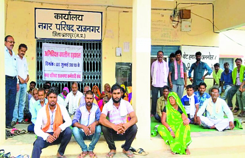 Sitting on fast for not getting salary वेतन नहीं मिलने पर तालाबंदी कर अनशन पर बैठे