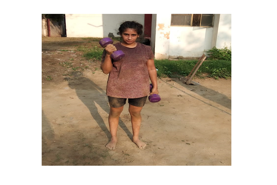 डॉ संपूर्णानंद स्पोर्ट्स स्टेडियम में डंबल का अभ्यास करती महिला पहलवान