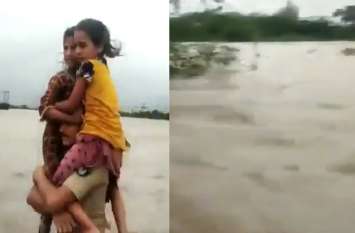 police constable rescued two children from gujarat floods video viral पुलिसवाला बना ' भगवान हनुमान', बच्चियों को कंधे पर बिठाकर बाढ़ से निकाला