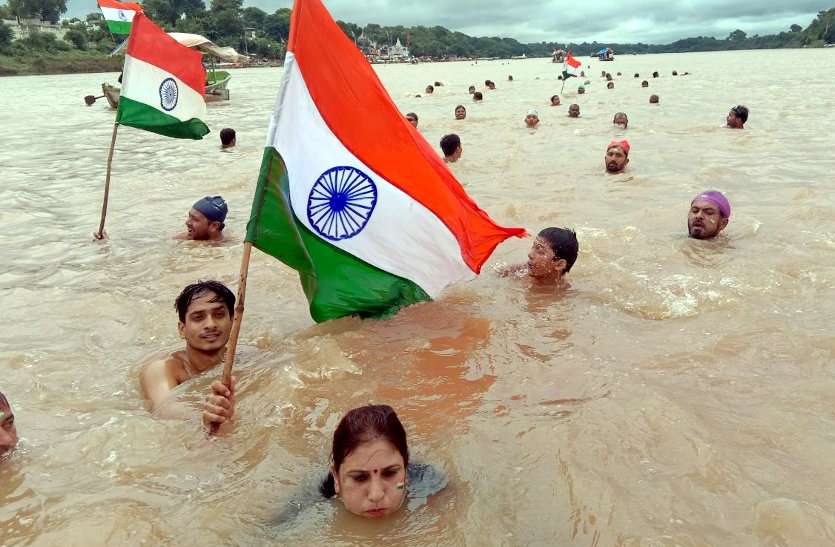 उफनती नर्मदा की लहरों में तिरंगा लेकर बच्चों साथ कूद गई महिला, कैमरे में हो गया लाइव रिकॉर्ड- देखें वीडियो नर्मदा की लहरों पर तिरंगा यात्रा आज जबलपुर। जोरदार बारिश और बरगी बांध के गेट खुलने के बाद से नर्मदा अपने प्रचंड वेग से बह रही हैं। उफनती लहरें जहां दूर से खूबसूरत दिखाई दे रही हैं, वहीं पास जाने पर जानलेवा खतरनाक हो रही हैं। ऐसी उफनती लहरों में दर्जनों की संख्या में महिलाएं और बच्चे हाथों में तिरंगा लेकर कूद गए। कूदने के बाद नर्मदा की लहरों ने उन्हें अपने आवेश में ले लिया। ये दृश्य जिसने भी देखा देखता ही रह गया। घाट किनारे खड़े लोग इस दृश्य का वीडियो बनाते हुए नजर आ रहे थे। हर तरफ भारत माता की जय, वंदे मातरम और अखंड भारत अखंड देश का नारा गूंजने लगा। चौंकिए नहीं ये कोई खतरनाक सीन नहीं है, बल्कि देशभक्ति को प्रदर्शित करने और एक देश एक समाज, एक मनावता का संदेश देने वाली तिरंगा यात्रा का है। अखंड भारत संकल्प यात्रा के माध्यम से पिछले 11 सालों से नर्मदा के तैराक ग्वारीघाट से तिलवाराघाट तक ऐसी उफनती नदी में तिरंगा लेकर निकलते हैं। जिन्हें देखने दूर दूर से लोग बड़ी संख्या में आते हैं। यात्रा के संयोजक विवेक यादव के अनुसार इस अखंड भारत संकल्प यात्रा का उद्देश्य लोगों में देशभक्ति का जज्बा पैदा करना तथा प्रकृति प्रधान इस देश की प्रकृति का संरक्षण करने का संदेश देना है। यात्रा में छोटे बच्चों से लेकर महिलाएं, व बुजुर्ग तैराक शामिल हैं। यह देखने में जितनी अच्छी लगती है, उतनी ही खतरनाक तैराकी होती है। नर्मदा अपने प्रचंड वेग से प्रवाहित होती हैं। हालांकि सुरक्षा का ख्याल भी रखा जाता है, लेकिन तैराकों का जोश लहरों को चीरकर अपनी मंजिल पा लेता है। यात्रा का समापन तिलवाराघाट में राष्ट्रगान के साथ होगा, साथ ही प्रतिभागियों को सम्मान पत्र व स्मृति चिंह दिया जाएगा। 150 से ज्यादा तैराक शामिल जिलहरीघाट से सुबह 8.30 बजे शुरू हुई तिरंगा यात्रा में 150 से अधिक तैराक शामिल हुए। जिलहरीघाट नित्य तैराकी मंडल के विवेक यादव ने बताया कि 14 अगस्त को 11 वें वर्ष अखंड भारत संकल्प यात्रा निकाली गई। तैराक नर्मदा की अथाह जलराशि के बीच एक हाथ में तिरंगा लेकर तैराकी करते हुए जोश के साथ शामिल हुए। यात्रा जिलहरीघाट से ग्वारीघाट, खारीघाट, ललपुर गांव होते हुए यह यात्रा तिलवाराघाट पहुंचकर सम्पन्न हुई। दक्ष तैराकों की निगरानी में तिरंगा यात्रा पूरी होती है। उफनती नर्मदा की लहरों में तिरंगा लेकर बच्चों साथ कूद गई महिला, कैमरे में हो गया लाइव रिकॉर्ड- देखें वीडियो