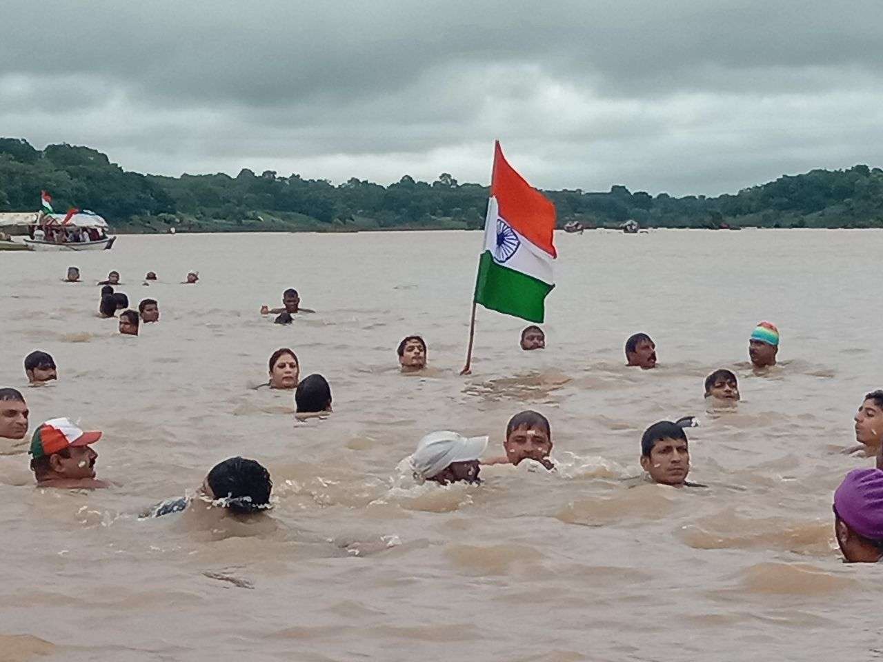 उफनती नर्मदा की लहरों में तिरंगा लेकर बच्चों साथ कूद गई महिला, कैमरे में हो गया लाइव रिकॉर्ड- देखें वीडियो नर्मदा की लहरों पर तिरंगा यात्रा आज जबलपुर। जोरदार बारिश और बरगी बांध के गेट खुलने के बाद से नर्मदा अपने प्रचंड वेग से बह रही हैं। उफनती लहरें जहां दूर से खूबसूरत दिखाई दे रही हैं, वहीं पास जाने पर जानलेवा खतरनाक हो रही हैं। ऐसी उफनती लहरों में दर्जनों की संख्या में महिलाएं और बच्चे हाथों में तिरंगा लेकर कूद गए। कूदने के बाद नर्मदा की लहरों ने उन्हें अपने आवेश में ले लिया। ये दृश्य जिसने भी देखा देखता ही रह गया। घाट किनारे खड़े लोग इस दृश्य का वीडियो बनाते हुए नजर आ रहे थे। हर तरफ भारत माता की जय, वंदे मातरम और अखंड भारत अखंड देश का नारा गूंजने लगा। चौंकिए नहीं ये कोई खतरनाक सीन नहीं है, बल्कि देशभक्ति को प्रदर्शित करने और एक देश एक समाज, एक मनावता का संदेश देने वाली तिरंगा यात्रा का है। अखंड भारत संकल्प यात्रा के माध्यम से पिछले 11 सालों से नर्मदा के तैराक ग्वारीघाट से तिलवाराघाट तक ऐसी उफनती नदी में तिरंगा लेकर निकलते हैं। जिन्हें देखने दूर दूर से लोग बड़ी संख्या में आते हैं। यात्रा के संयोजक विवेक यादव के अनुसार इस अखंड भारत संकल्प यात्रा का उद्देश्य लोगों में देशभक्ति का जज्बा पैदा करना तथा प्रकृति प्रधान इस देश की प्रकृति का संरक्षण करने का संदेश देना है। यात्रा में छोटे बच्चों से लेकर महिलाएं, व बुजुर्ग तैराक शामिल हैं। यह देखने में जितनी अच्छी लगती है, उतनी ही खतरनाक तैराकी होती है। नर्मदा अपने प्रचंड वेग से प्रवाहित होती हैं। हालांकि सुरक्षा का ख्याल भी रखा जाता है, लेकिन तैराकों का जोश लहरों को चीरकर अपनी मंजिल पा लेता है। यात्रा का समापन तिलवाराघाट में राष्ट्रगान के साथ होगा, साथ ही प्रतिभागियों को सम्मान पत्र व स्मृति चिंह दिया जाएगा। 150 से ज्यादा तैराक शामिल जिलहरीघाट से सुबह 8.30 बजे शुरू हुई तिरंगा यात्रा में 150 से अधिक तैराक शामिल हुए। जिलहरीघाट नित्य तैराकी मंडल के विवेक यादव ने बताया कि 14 अगस्त को 11 वें वर्ष अखंड भारत संकल्प यात्रा निकाली गई। तैराक नर्मदा की अथाह जलराशि के बीच एक हाथ में तिरंगा लेकर तैराकी करते हुए जोश के साथ शामिल हुए। यात्रा जिलहरीघाट से ग्वारीघाट, खारीघाट, ललपुर गांव होते हुए यह यात्रा तिलवाराघाट पहुंचकर सम्पन्न हुई। दक्ष तैराकों की निगरानी में तिरंगा यात्रा पूरी होती है।