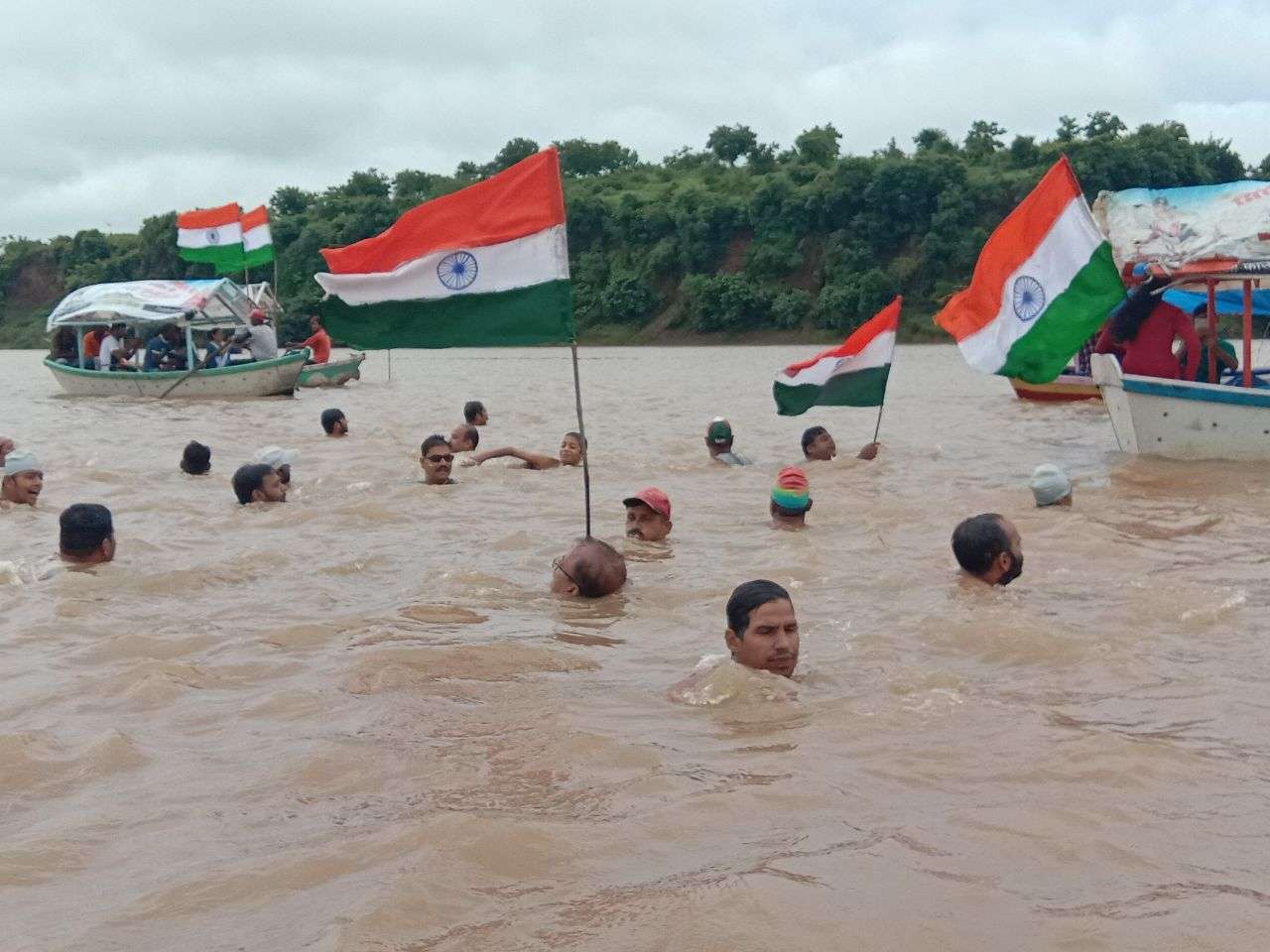 उफनती नर्मदा की लहरों में तिरंगा लेकर बच्चों साथ कूद गई महिला, कैमरे में हो गया लाइव रिकॉर्ड- देखें वीडियो नर्मदा की लहरों पर तिरंगा यात्रा आज जबलपुर। जोरदार बारिश और बरगी बांध के गेट खुलने के बाद से नर्मदा अपने प्रचंड वेग से बह रही हैं। उफनती लहरें जहां दूर से खूबसूरत दिखाई दे रही हैं, वहीं पास जाने पर जानलेवा खतरनाक हो रही हैं। ऐसी उफनती लहरों में दर्जनों की संख्या में महिलाएं और बच्चे हाथों में तिरंगा लेकर कूद गए। कूदने के बाद नर्मदा की लहरों ने उन्हें अपने आवेश में ले लिया। ये दृश्य जिसने भी देखा देखता ही रह गया। घाट किनारे खड़े लोग इस दृश्य का वीडियो बनाते हुए नजर आ रहे थे। हर तरफ भारत माता की जय, वंदे मातरम और अखंड भारत अखंड देश का नारा गूंजने लगा। चौंकिए नहीं ये कोई खतरनाक सीन नहीं है, बल्कि देशभक्ति को प्रदर्शित करने और एक देश एक समाज, एक मनावता का संदेश देने वाली तिरंगा यात्रा का है। अखंड भारत संकल्प यात्रा के माध्यम से पिछले 11 सालों से नर्मदा के तैराक ग्वारीघाट से तिलवाराघाट तक ऐसी उफनती नदी में तिरंगा लेकर निकलते हैं। जिन्हें देखने दूर दूर से लोग बड़ी संख्या में आते हैं। यात्रा के संयोजक विवेक यादव के अनुसार इस अखंड भारत संकल्प यात्रा का उद्देश्य लोगों में देशभक्ति का जज्बा पैदा करना तथा प्रकृति प्रधान इस देश की प्रकृति का संरक्षण करने का संदेश देना है। यात्रा में छोटे बच्चों से लेकर महिलाएं, व बुजुर्ग तैराक शामिल हैं। यह देखने में जितनी अच्छी लगती है, उतनी ही खतरनाक तैराकी होती है। नर्मदा अपने प्रचंड वेग से प्रवाहित होती हैं। हालांकि सुरक्षा का ख्याल भी रखा जाता है, लेकिन तैराकों का जोश लहरों को चीरकर अपनी मंजिल पा लेता है। यात्रा का समापन तिलवाराघाट में राष्ट्रगान के साथ होगा, साथ ही प्रतिभागियों को सम्मान पत्र व स्मृति चिंह दिया जाएगा। 150 से ज्यादा तैराक शामिल जिलहरीघाट से सुबह 8.30 बजे शुरू हुई तिरंगा यात्रा में 150 से अधिक तैराक शामिल हुए। जिलहरीघाट नित्य तैराकी मंडल के विवेक यादव ने बताया कि 14 अगस्त को 11 वें वर्ष अखंड भारत संकल्प यात्रा निकाली गई। तैराक नर्मदा की अथाह जलराशि के बीच एक हाथ में तिरंगा लेकर तैराकी करते हुए जोश के साथ शामिल हुए। यात्रा जिलहरीघाट से ग्वारीघाट, खारीघाट, ललपुर गांव होते हुए यह यात्रा तिलवाराघाट पहुंचकर सम्पन्न हुई। दक्ष तैराकों की निगरानी में तिरंगा यात्रा पूरी होती है।