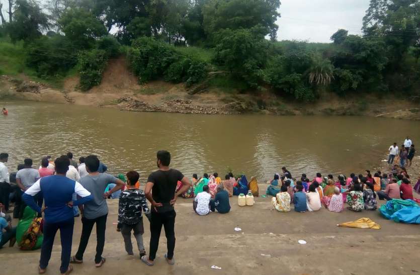 Families sitting on a hungry-thirsty anket. किशोर के परिजनों ने लगाए गोताखोर और हैलोजन लाइट