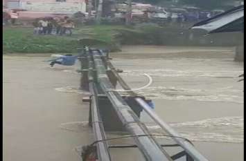 Young man crossing the rough river of the pipeline dropped नेवज की पुलिया के ऊपर से निकल रहा पानी, पाइप लाइन के सहारे नदी पार कर रहा युवक गिरा