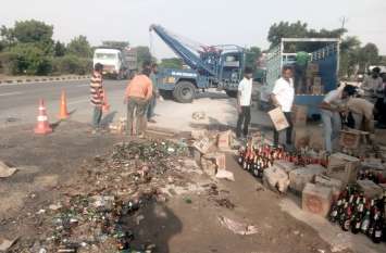 Pickup overturned with alcohol, robbed सड़क पर बिखरी शराब की बोतलें, कई किलोमीटर दूर से लूटने आए लोग