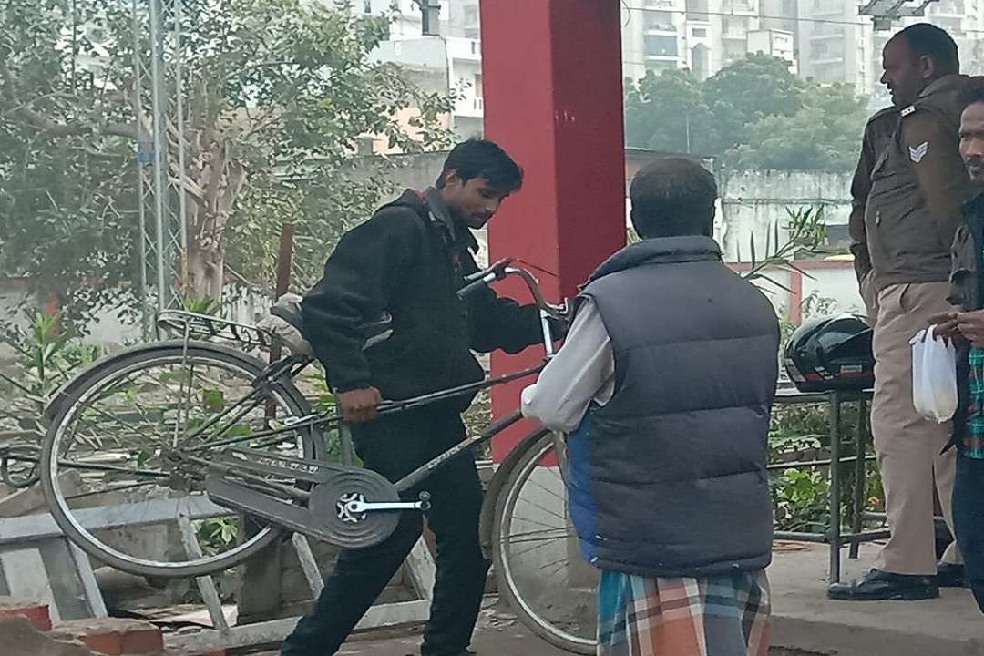 बंद फाटक को पार करता साइकिल सवार