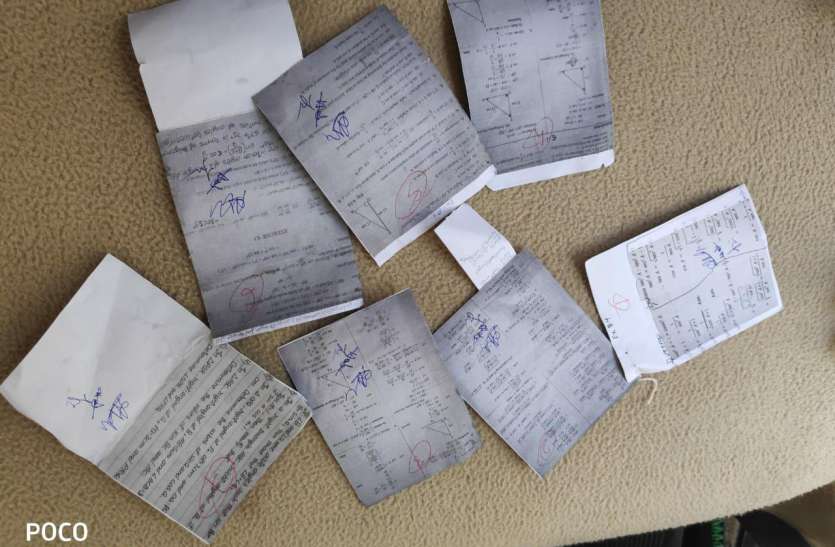 The student had trapped pages of copy in the middle of the leaflet पर्चे के बीच में छात्रा ने फंसा रखे थे नकल के पन्ने