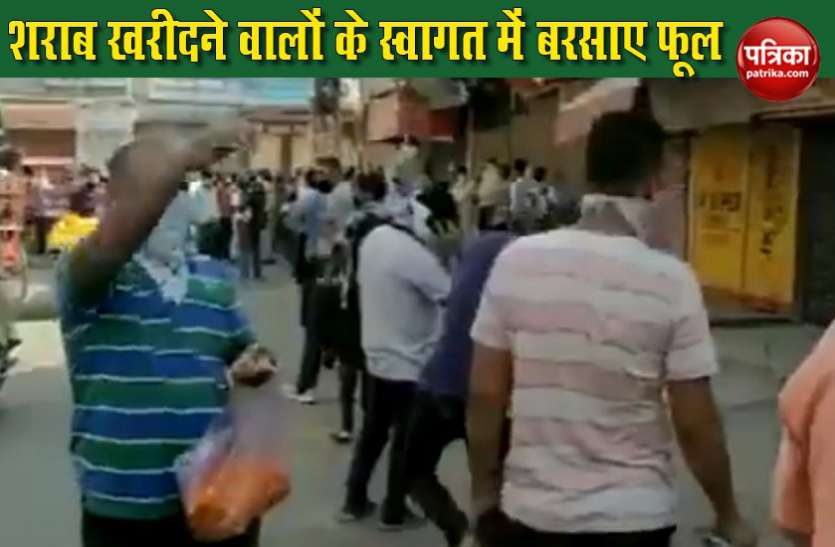 Viral Video शराब खरीदने के लिए कतार में लगे थे लोग, स्वागत में बरसाए फूल