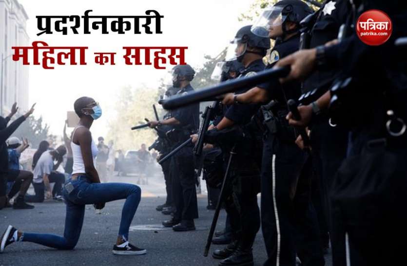 ameica America: प्रदर्शनकारी महिला ने पुलिस के सामने घुटने के बल खड़ी होकर जताया विरोध, तस्वीर वायरल