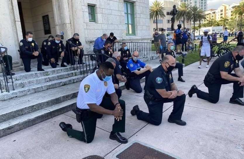 american protest George Floyd Death: गुस्साई भीड़ को शांत करने के लिए घुटनों पर बैठे पुलिसकर्मी, घटना पर शोक प्रकट किया