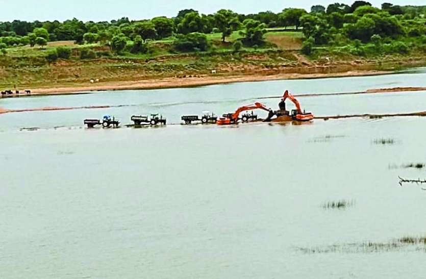 Heavy machine-fired sand in Rampur Ghat of Cane River केन नदी के रामपुर घाट में हैवी मशीन से निकाल रहे रेत