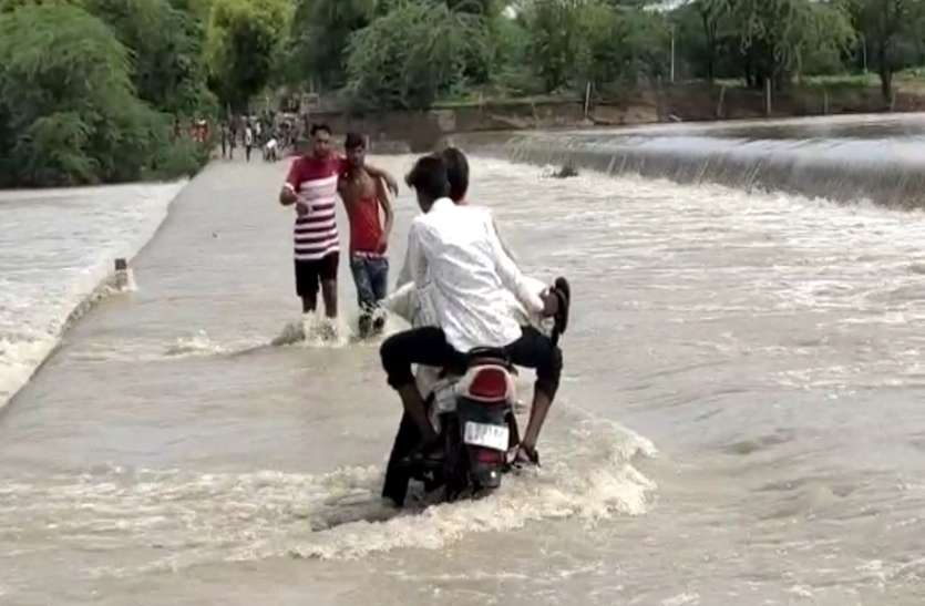 खतरे में डाल रहे जान, बहते पानी को पार कर रहे लोग खतरे में डाल रहे जान, बहते पानी को पार कर रहे लोग