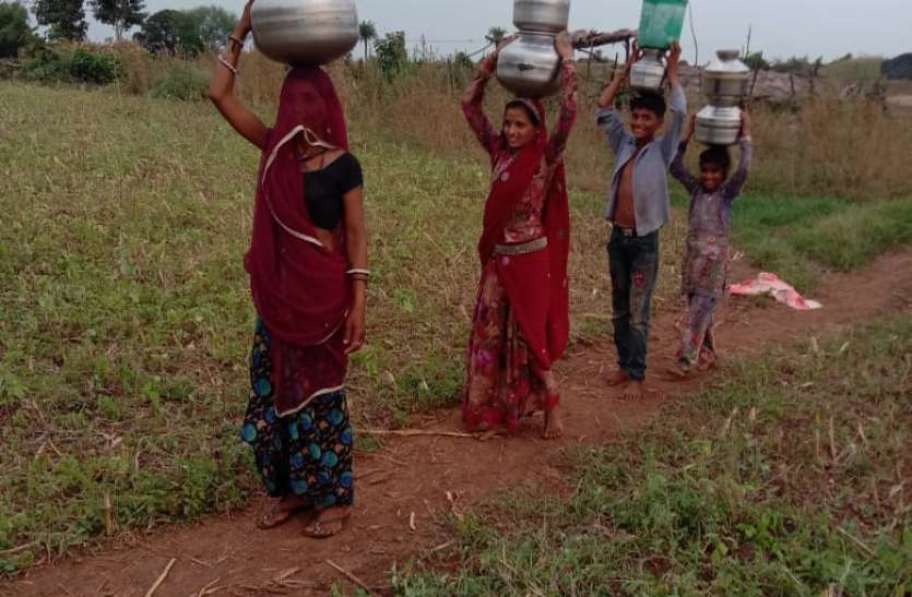 बारिश में भी दूर से पानी ढोने को मजबूर महिलाएं और बच्चे बारिश में भी दूर से पानी ढोने को मजबूर महिलाएं और बच्चे