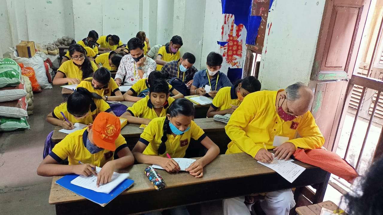 एक रिटायर्ड आईजी बैठे बच्चों के साथ अ,आ,इ की परीक्षा में