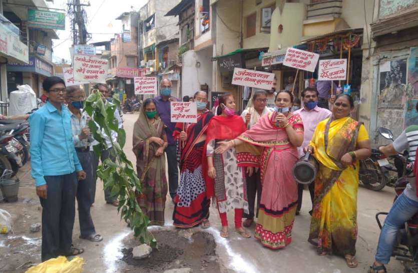 After landing on the road, women planted a shameless plant in the pit, now fill the pit, sir सड़क पर उतरकर महिलाओं ने गड्ढें में लगाया बेशर्म का पौधा, अब तो गड्ढें भर दो साहब