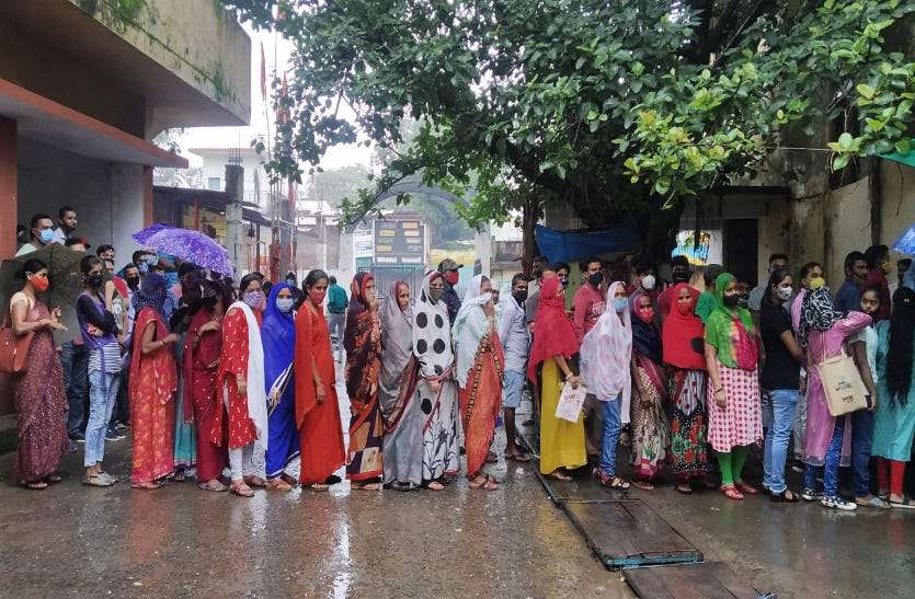 Citizens waiting for their turn to get vaccinated while getting wet in the rain at Kachhari Complex Vaccination Centre. बारिश के बीच वैक्सीनेशन की कतार, भीगते हुए अपनी बारी का इंतजार