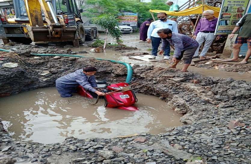 अपनी गाड़ी सहित सड़क पर बने 6 फीट गहरे गड्ढे में जा गिरा वाहन चालक, जेसीबी से निकाली गाड़ी