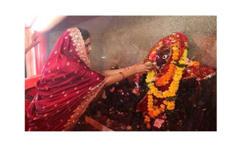 देवी प्रतिमा का जलाभिषेक करती भक्त