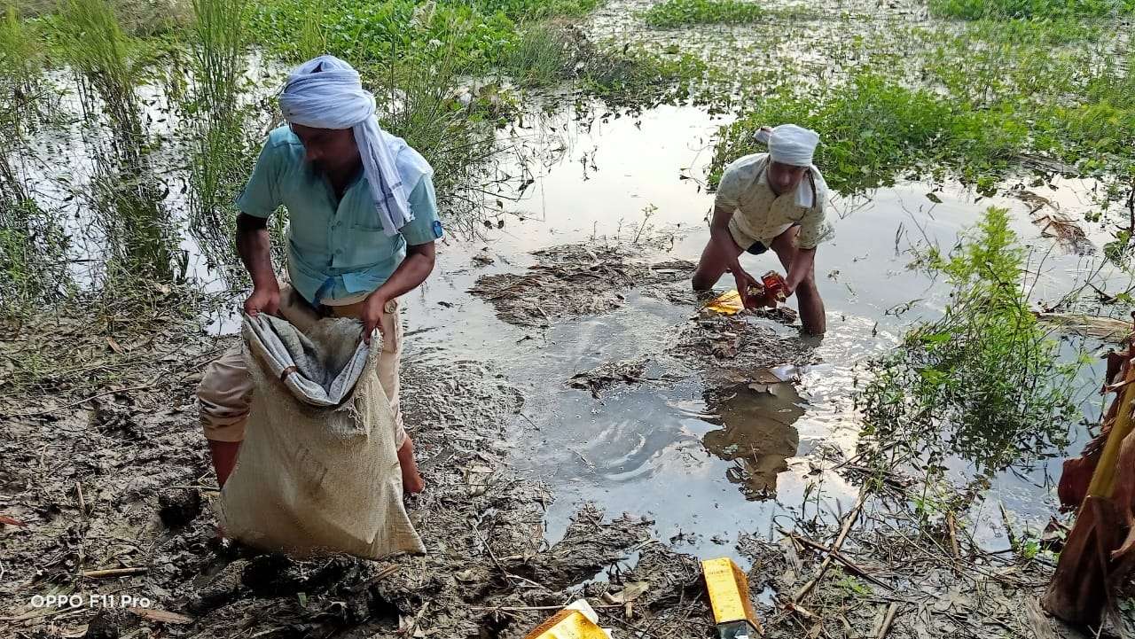 police_searches_pond_and_finds_477_litres_imported_liquor_bottles_in_bihar.jpg