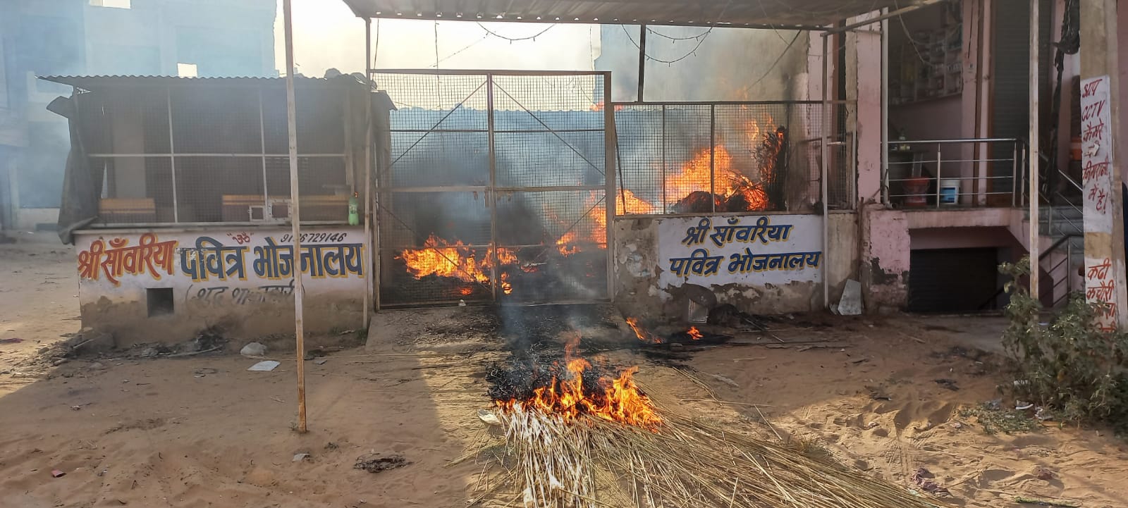 आग से घिरा बुजुर्ग, ग्रामीणों ने जाली तोड़कर बाहर निकाला