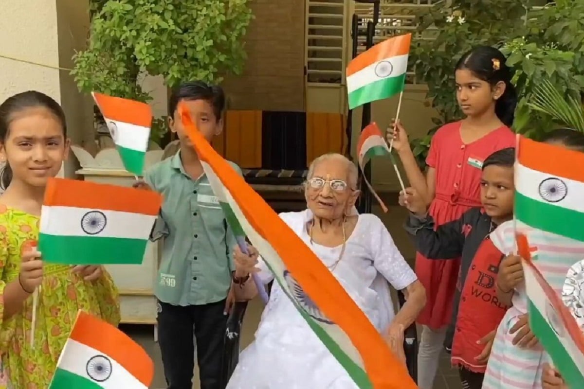 Heeraben Modi, mother of Prime Minister Narendra Modi distributes national flag to children and hoists the tricolour as 'Har Ghar Tiranga' campaign begins today