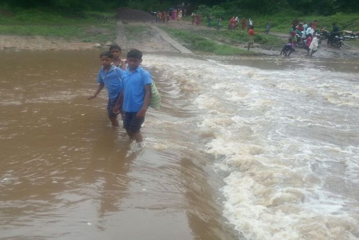 student forced to cross river शिक्षा है जरूरी, पर स्कूल पहुंचने के लिए उफनती नदी पार करना है मजबूरी
